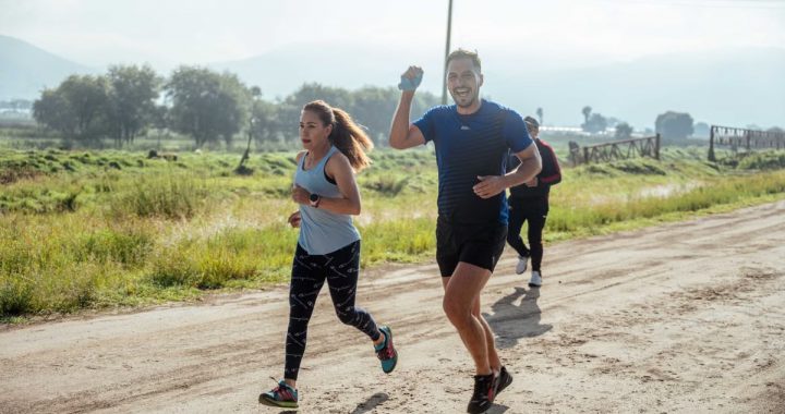 A group of runners enjoys a vibrant morning jog on a rural dirt road.